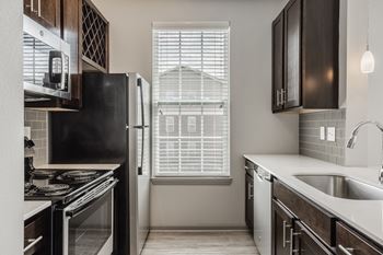 A kitchen with black appliances and wooden cabinets